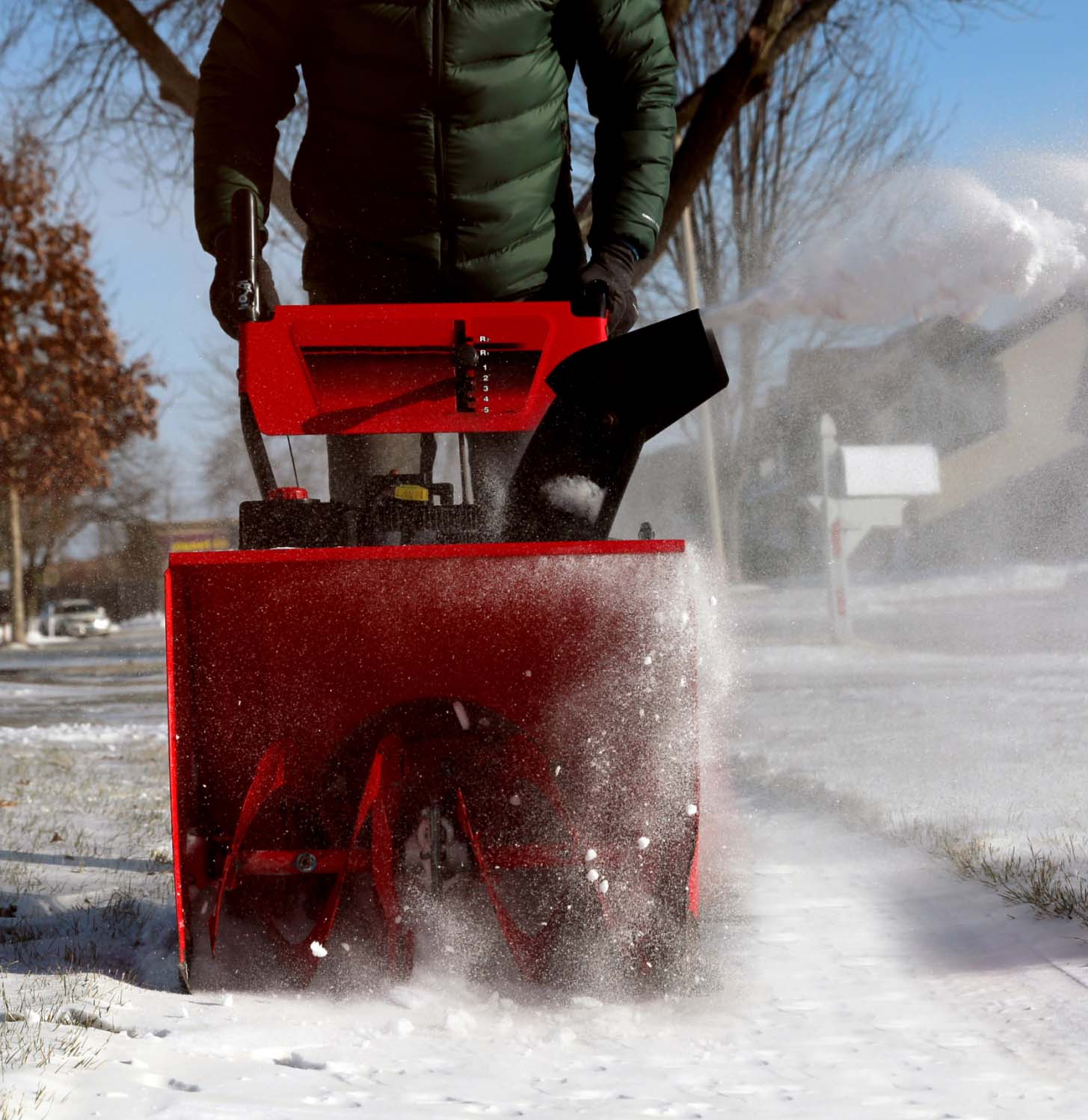 Professional snow removal service clearing snowy sidewalk with a powerful red snowblower, ensuring safe passage.